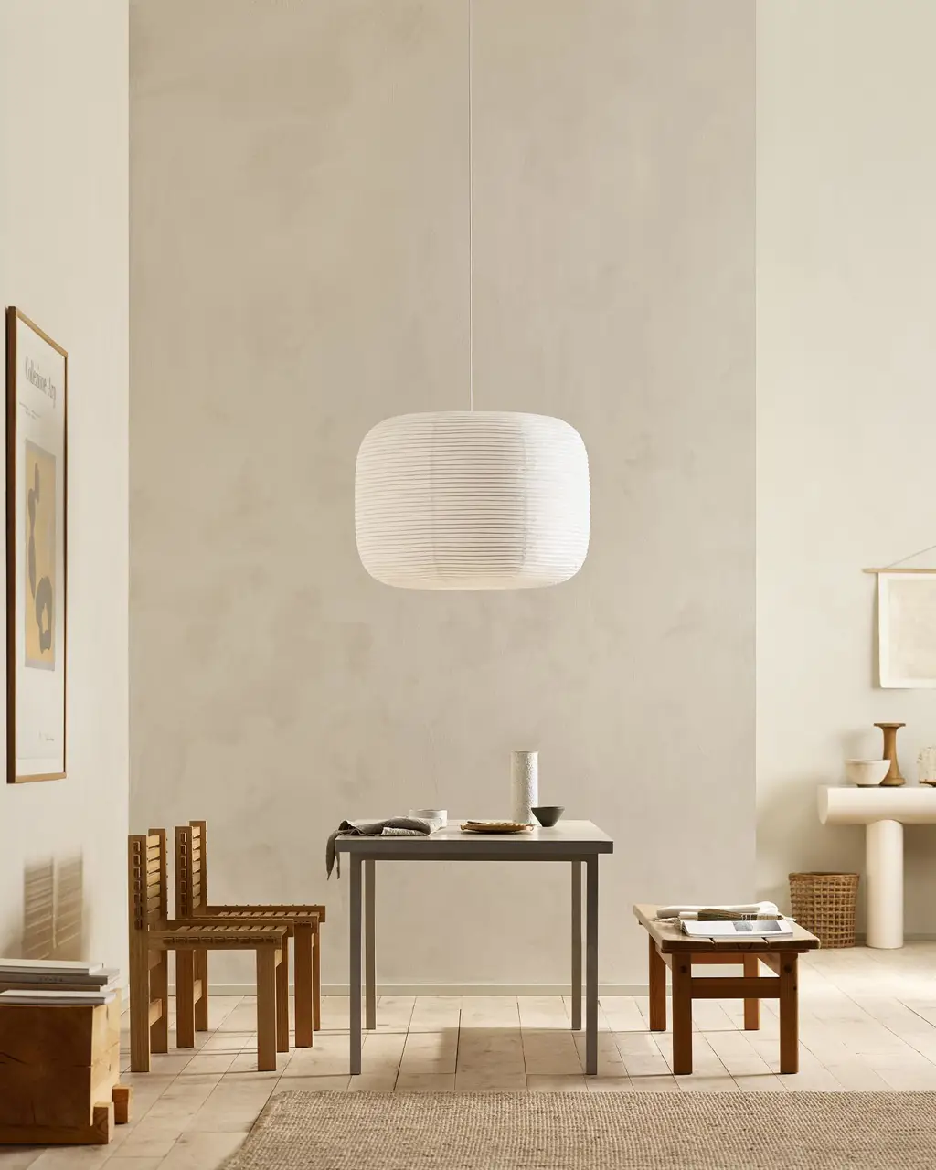 Minimalist dining area with wooden chairs, pendant light, and golden beige walls painted with the colour 12308 Unbleached from Jotun.